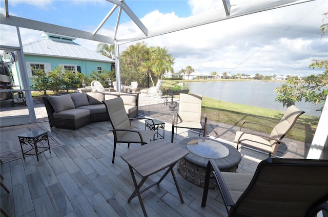 view of patio / terrace featuring a water view and an outdoor living space with a fire pit