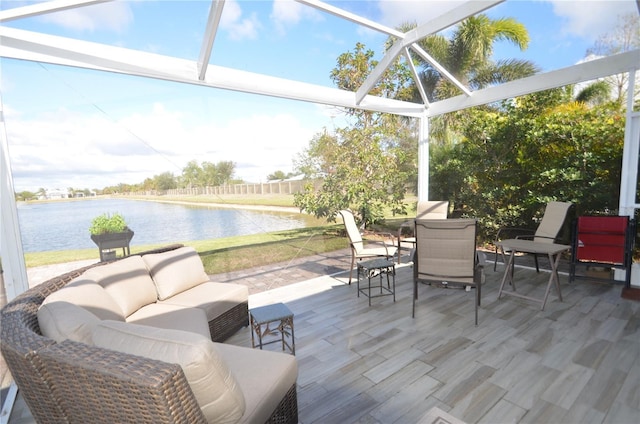 view of patio with glass enclosure, an outdoor living space, and a water view