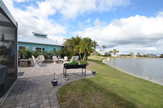 exterior space featuring a water view, glass enclosure, and a patio area