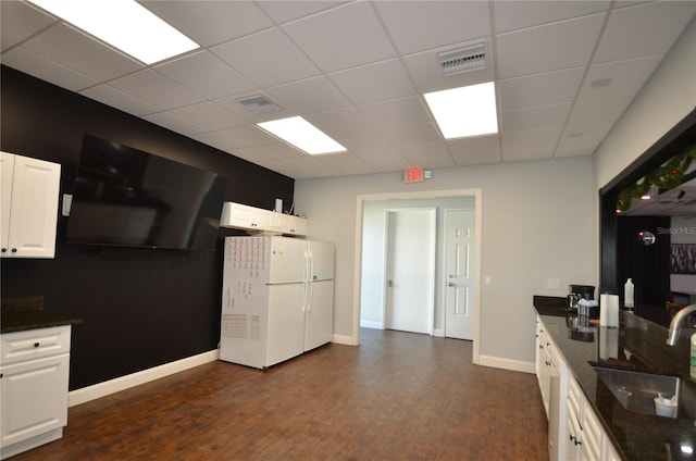 kitchen featuring dark hardwood / wood-style flooring, white refrigerator, white cabinetry, and sink