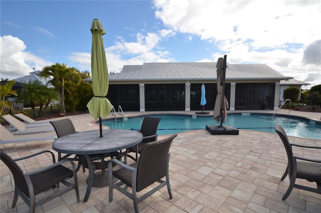 view of swimming pool featuring a patio area and a sunroom