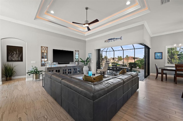 living room featuring a wealth of natural light, light hardwood / wood-style flooring, ceiling fan, and ornamental molding