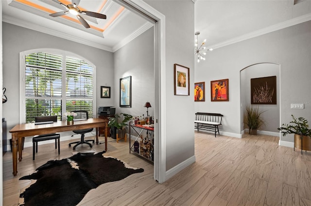 home office with crown molding, ceiling fan with notable chandelier, and light wood-type flooring