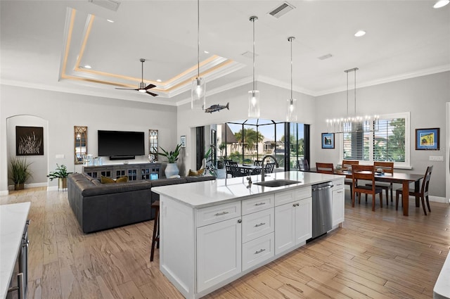 kitchen with sink, light hardwood / wood-style flooring, dishwasher, white cabinetry, and an island with sink