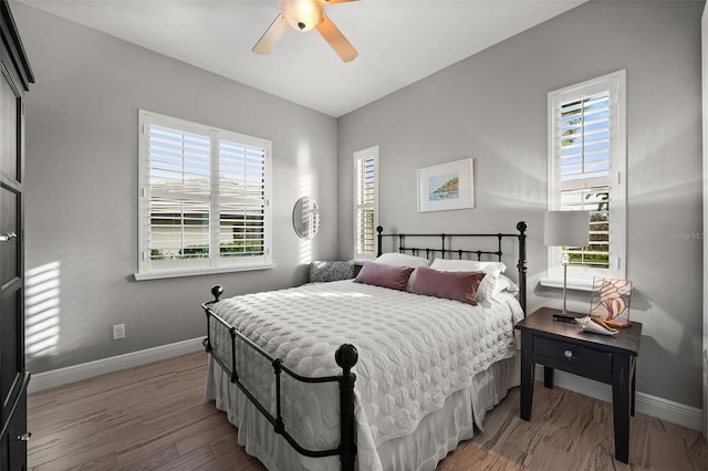 bedroom with ceiling fan, light wood-type flooring, and multiple windows