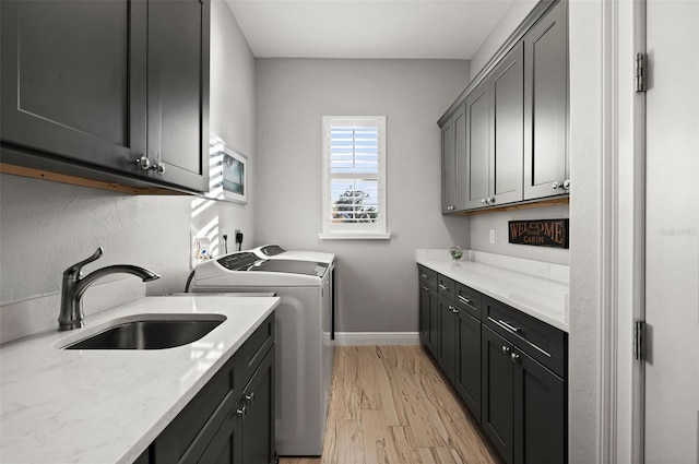 washroom featuring cabinets, light wood-type flooring, sink, and separate washer and dryer