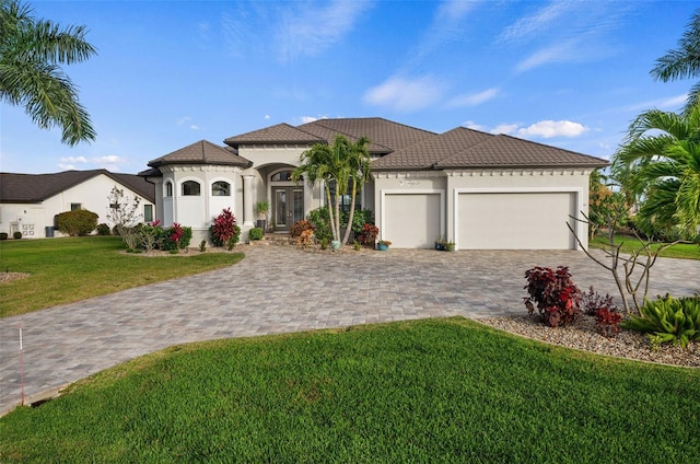 mediterranean / spanish house with a front yard and a garage