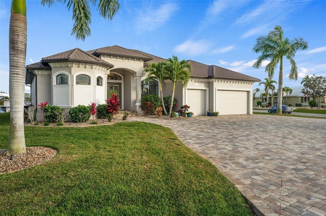 mediterranean / spanish house with a garage and a front lawn