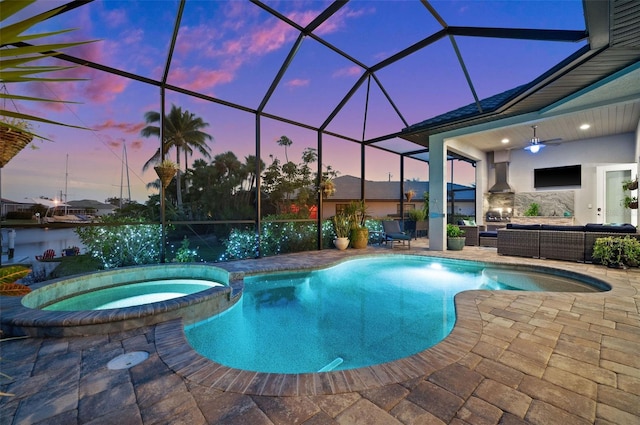 view of pool featuring outdoor lounge area, glass enclosure, ceiling fan, an in ground hot tub, and a patio area