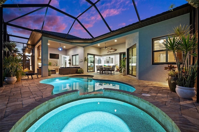 view of swimming pool with ceiling fan, a patio area, an in ground hot tub, and glass enclosure