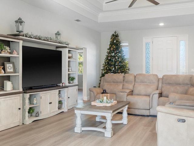 living room featuring ceiling fan, light wood-type flooring, and crown molding