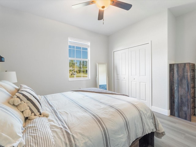 bedroom with ceiling fan, a closet, and light hardwood / wood-style flooring