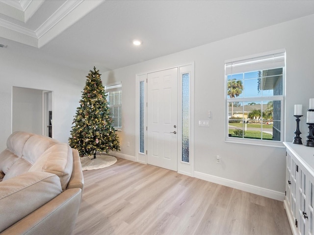 foyer entrance with light hardwood / wood-style floors and crown molding