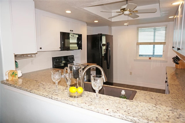 kitchen with black appliances, ceiling fan, light stone countertops, and white cabinetry