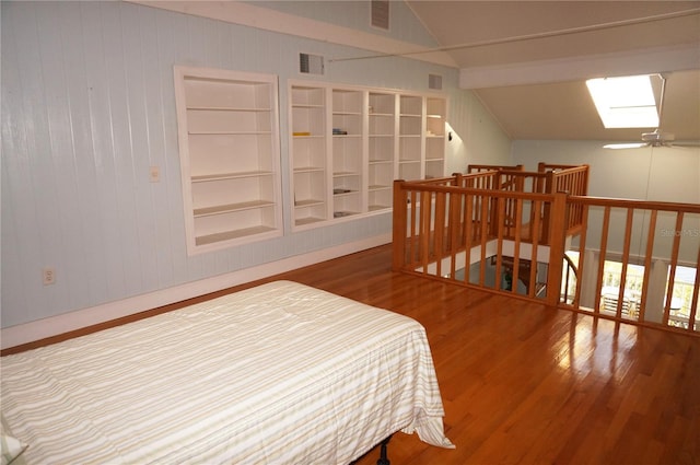 bedroom with lofted ceiling with skylight and hardwood / wood-style floors