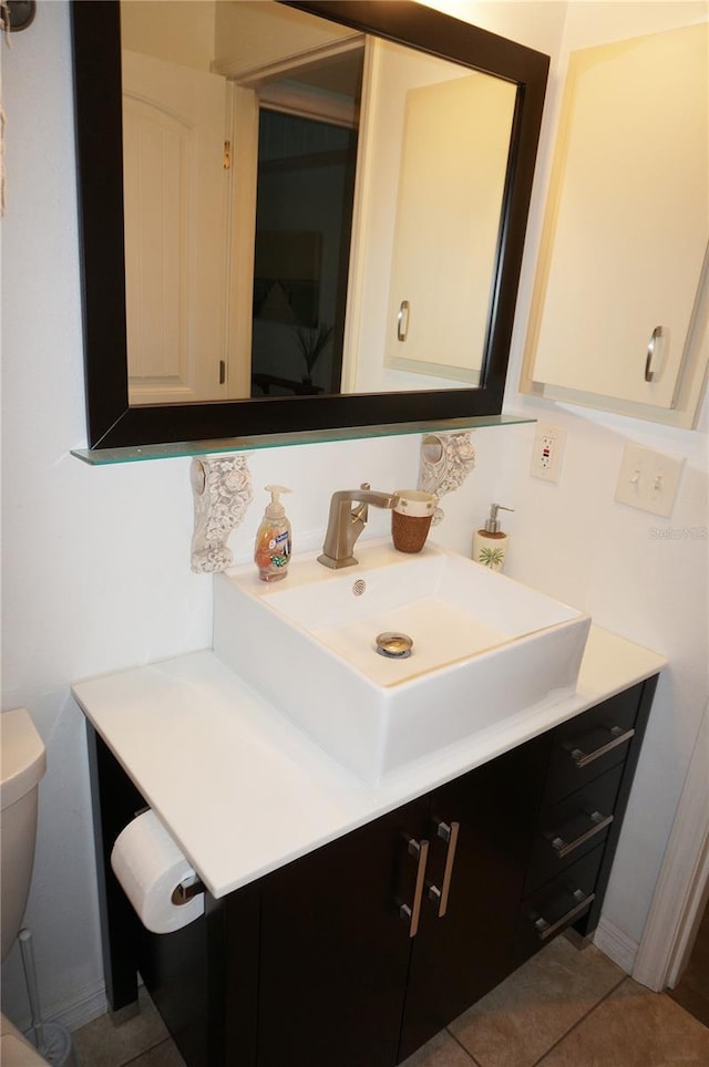 bathroom with tile patterned flooring, vanity, and toilet