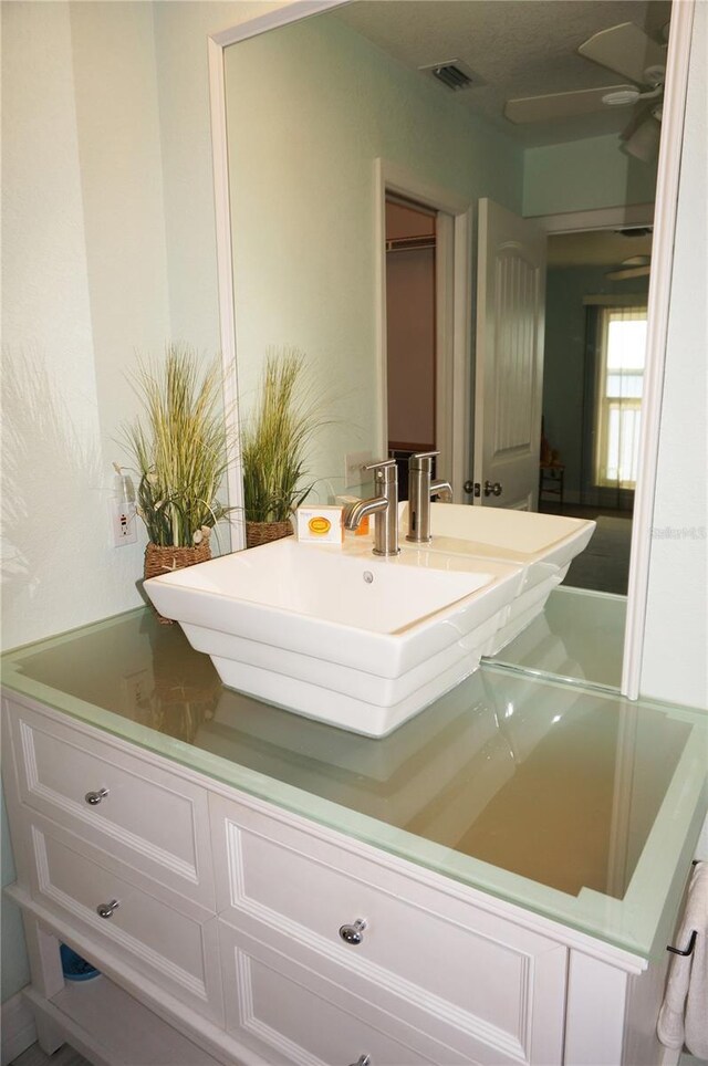 bathroom with ceiling fan and vanity