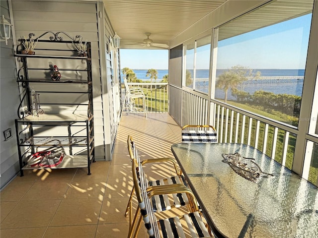 balcony with ceiling fan and a water view