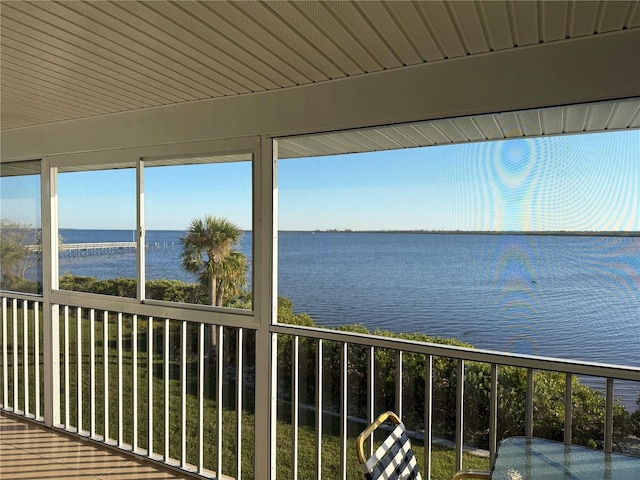 unfurnished sunroom with a water view