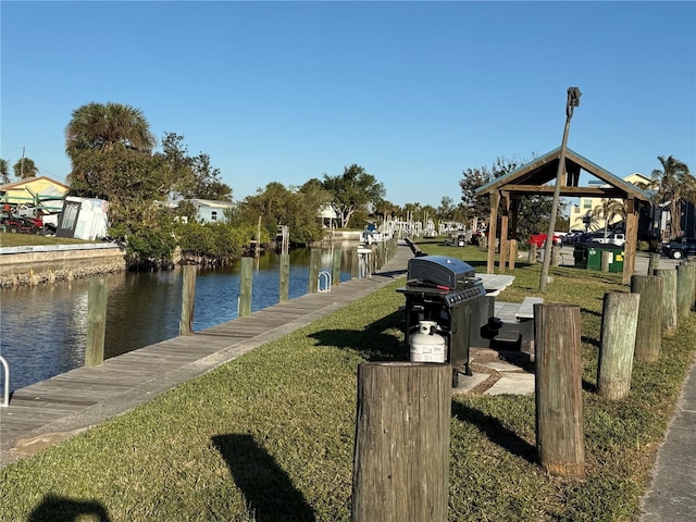 dock area featuring a lawn and a water view