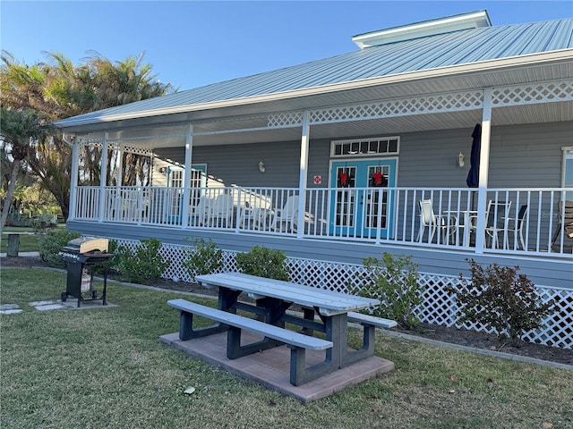 rear view of property featuring a porch and a lawn