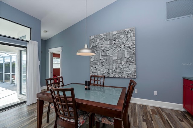 dining area featuring lofted ceiling and dark wood-type flooring