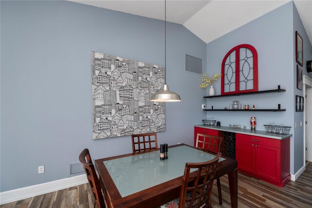 dining area featuring dark hardwood / wood-style floors and vaulted ceiling