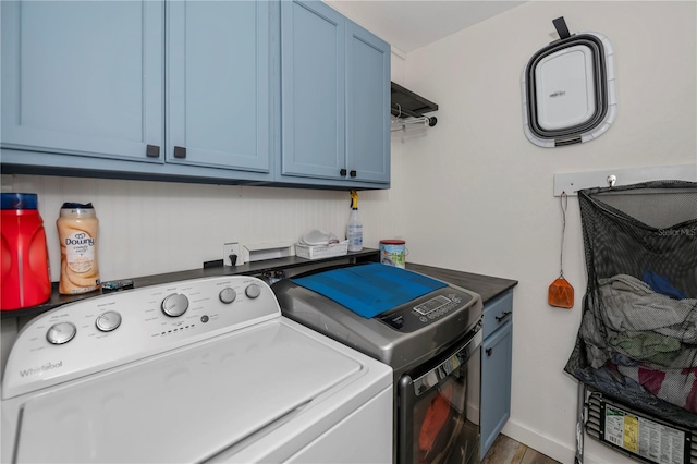 washroom featuring cabinets, washing machine and dryer, and hardwood / wood-style flooring