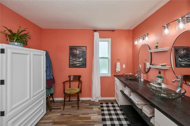 bathroom featuring a textured ceiling, vanity, and hardwood / wood-style flooring