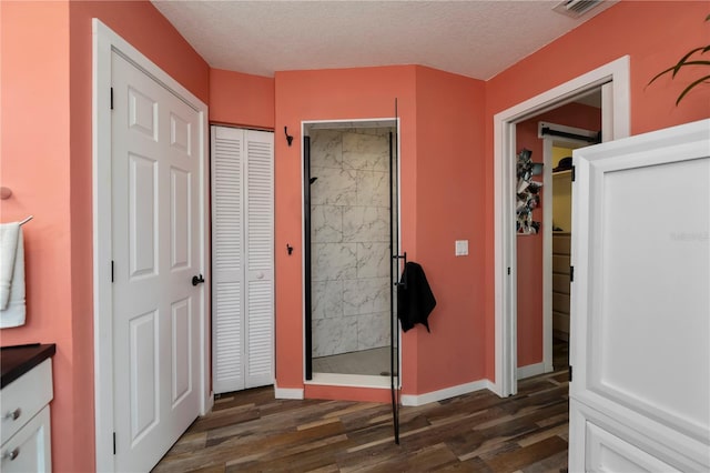 interior space with a shower, hardwood / wood-style floors, vanity, and a textured ceiling