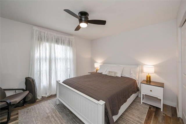 bedroom with dark hardwood / wood-style flooring and ceiling fan