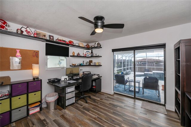 office featuring dark hardwood / wood-style floors, ceiling fan, and a textured ceiling