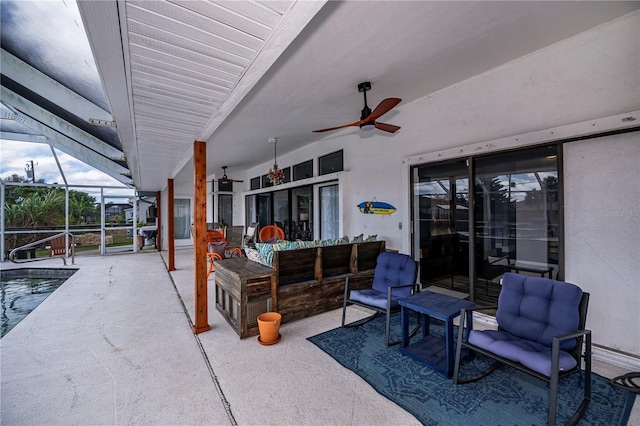 view of patio with outdoor lounge area, glass enclosure, and ceiling fan