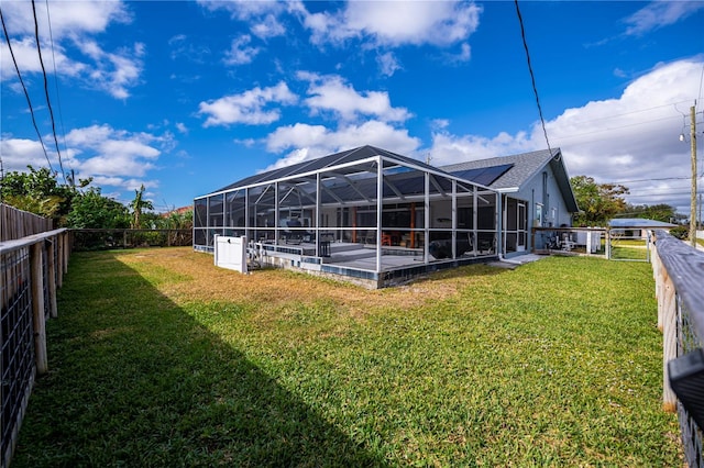 rear view of property featuring glass enclosure and a yard