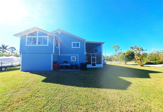 back of house featuring a lawn and a sunroom