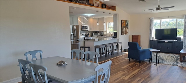 dining space featuring vaulted ceiling, ceiling fan, dark wood-type flooring, and sink