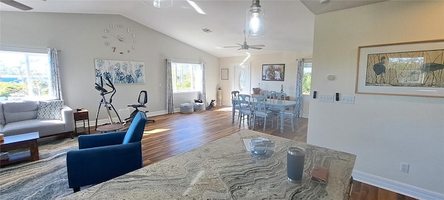 living room with hardwood / wood-style flooring, vaulted ceiling, and ceiling fan