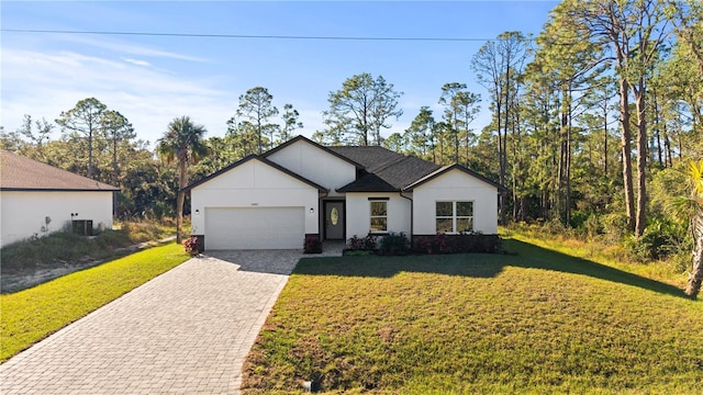 view of front facade with a garage, central air condition unit, and a front lawn