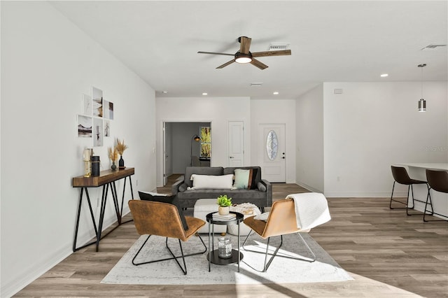 living room featuring light hardwood / wood-style floors and ceiling fan