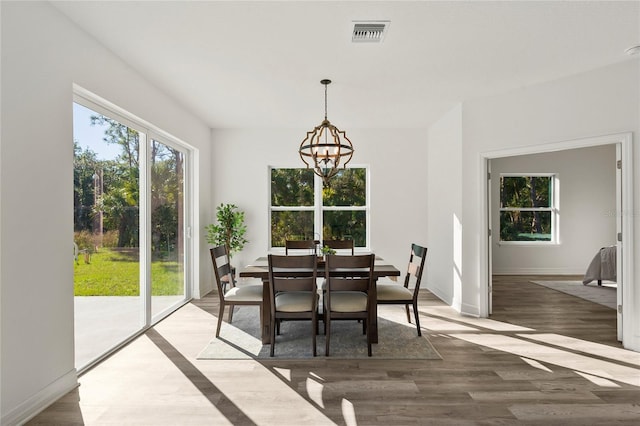 dining room featuring dark hardwood / wood-style flooring, plenty of natural light, and a notable chandelier