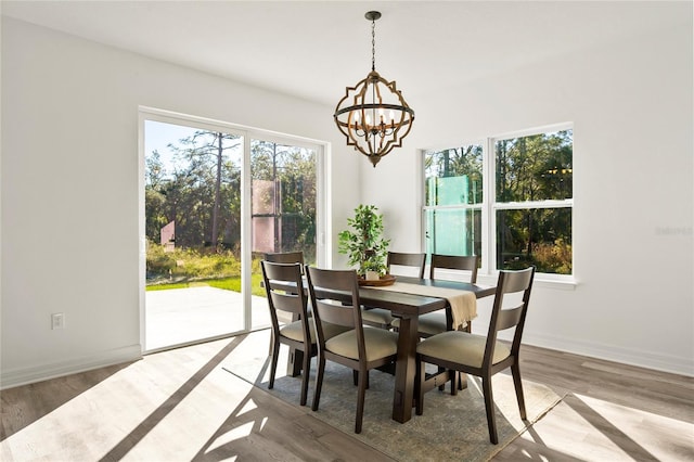 dining room with light hardwood / wood-style floors and a notable chandelier