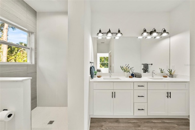 bathroom featuring vanity, a shower, and wood-type flooring