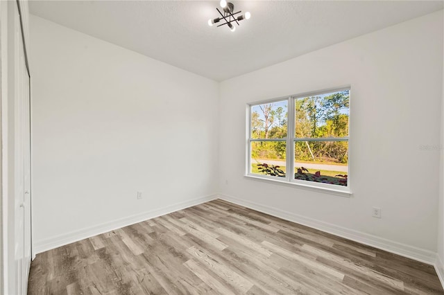 empty room with a textured ceiling and light wood-type flooring