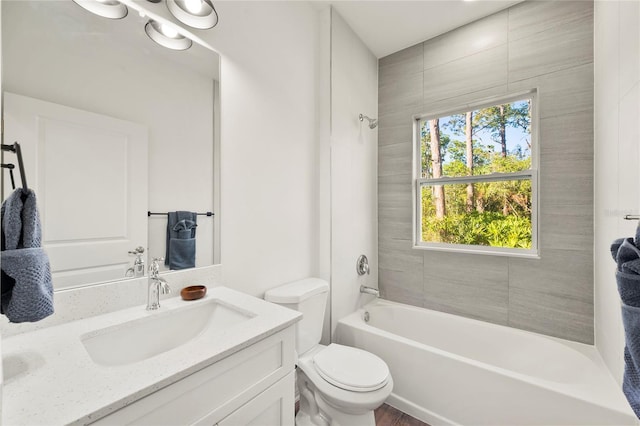 full bathroom with vanity, tiled shower / bath combo, and toilet