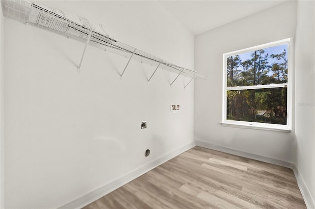 clothes washing area with washer hookup, electric dryer hookup, and light hardwood / wood-style flooring