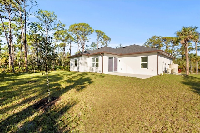 back of property with a yard and a patio