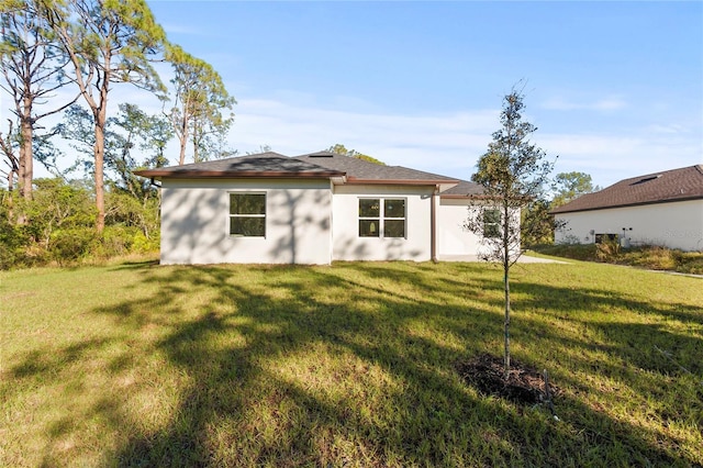 rear view of house featuring a lawn