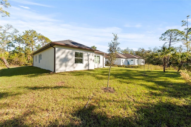 rear view of property featuring a lawn