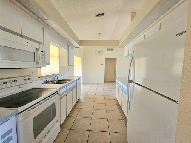 kitchen with white appliances, sink, pendant lighting, white cabinets, and light tile patterned flooring