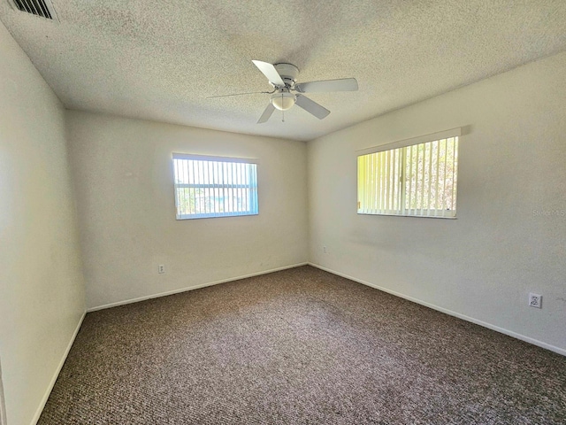 spare room with carpet, ceiling fan, and a textured ceiling